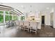 Open kitchen and dining area with island seating, modern lighting, and large windows offering scenic views at 7812 Seton House Ln, Charlotte, NC 28277