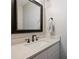 Well-lit bathroom featuring a modern sink with an ornate faucet and a decorative framed mirror above at 7833 Taymouth Ln, Charlotte, NC 28269