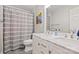 Bright bathroom featuring a double sink vanity with marble countertop and stylish gray striped shower curtain at 7833 Taymouth Ln, Charlotte, NC 28269