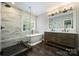 A luxurious bathroom featuring a freestanding tub, a glass-enclosed shower, and double sink vanity at 7833 Taymouth Ln, Charlotte, NC 28269