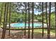 Community pool with a waterslide, chairs and umbrellas surrounded by trees at 7833 Taymouth Ln, Charlotte, NC 28269
