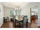 Elegant dining area featuring hardwood floors, a chandelier, and views into the kitchen at 7833 Taymouth Ln, Charlotte, NC 28269