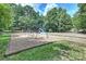 This is a playground complete with swings and slides nestled among mature trees, perfect for Gathering fun at 7833 Taymouth Ln, Charlotte, NC 28269