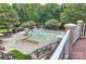 This is an aerial view of a community pool and splash pad surrounded by mature trees and ample seating at 7833 Taymouth Ln, Charlotte, NC 28269