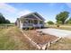 Charming single-story home featuring a cozy front porch and well-maintained yard with a decorative rock border and concrete driveway at 975 Mt Moriah Church Rd, China Grove, NC 28023