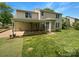 Spacious backyard with a covered patio, grassy area, and manicured landscaping at 10406 Baskerville Ave, Charlotte, NC 28269