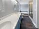 Bathroom showcasing double sinks, a soaking tub, and a glass-enclosed shower at 10406 Baskerville Ave, Charlotte, NC 28269
