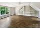 Large bonus room with hardwood floors, built-in shelving, and plenty of natural light from the window at 10406 Baskerville Ave, Charlotte, NC 28269