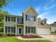 Charming two-story home featuring green shutters, a well-manicured lawn, and an attached two-car garage at 10406 Baskerville Ave, Charlotte, NC 28269