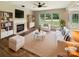 Bright and airy living room with fireplace, ceiling fan, and large windows overlooking the backyard at 10406 Baskerville Ave, Charlotte, NC 28269