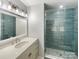 Updated shower with blue tile, pebble flooring, and a glass door in the stylish bathroom at 10406 Baskerville Ave, Charlotte, NC 28269
