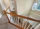 Open staircase with wood railing, carpeted steps, and hardwood flooring on the lower level at 10406 Baskerville Ave, Charlotte, NC 28269