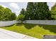 The backyard is spacious with mature trees and a pristine white fence at 10815 Mountain Springs Dr, Charlotte, NC 28278