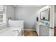 Bathroom featuring separate tub and double sink with quartz countertops, and natural light from a window at 10815 Mountain Springs Dr, Charlotte, NC 28278