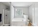 Relaxing bathroom featuring a soaking tub, a separate walk-in shower, and neutral finishes for a spa-like experience at 10815 Mountain Springs Dr, Charlotte, NC 28278