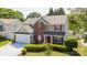 Inviting two-story home featuring a two-car garage, manicured lawn, and traditional architectural details at 10815 Mountain Springs Dr, Charlotte, NC 28278