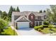 Traditional two-story home with a two-car garage, complemented by lush greenery and a manicured lawn at 10815 Mountain Springs Dr, Charlotte, NC 28278
