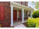 Cozy front porch with red door and white columns, offering a welcoming entrance to the home at 10815 Mountain Springs Dr, Charlotte, NC 28278