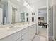 Bright bathroom with double sinks, white cabinets, and a view into a bedroom, great for getting ready at 11321 James Jack Ln, Charlotte, NC 28277