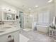 A luxurious bathroom featuring dual vanities, a glass-enclosed shower, and a freestanding soaking tub at 11321 James Jack Ln, Charlotte, NC 28277