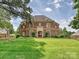 Beautiful brick home with lush green lawn, showcasing classic architecture and mature landscaping at 11321 James Jack Ln, Charlotte, NC 28277
