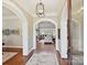 Elegant foyer with hardwood floors, decorative wallpaper, arched entrances, and a view into the living room at 11321 James Jack Ln, Charlotte, NC 28277