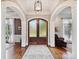 Grand foyer with hardwood floors, decorative doors, elegant lighting, and arched entryways at 11321 James Jack Ln, Charlotte, NC 28277