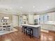 Open kitchen and breakfast nook featuring hardwood floors, white cabinets and an island with seating at 11321 James Jack Ln, Charlotte, NC 28277