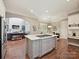 Kitchen island with cooktop and white countertops, adjacent to a living area with fireplace at 11321 James Jack Ln, Charlotte, NC 28277