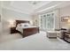 Serene main bedroom suite with a large window, tray ceiling and neutral color palette at 11321 James Jack Ln, Charlotte, NC 28277