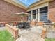 Back patio with dining table and umbrella, complemented by a built-in grill and brick accents at 11321 James Jack Ln, Charlotte, NC 28277