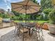 Outdoor dining area with stone patio, featuring an umbrella table and built-in grill at 11321 James Jack Ln, Charlotte, NC 28277