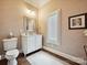 Elegant powder room featuring a white vanity, framed mirror, and shuttered window for natural light at 11321 James Jack Ln, Charlotte, NC 28277