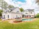 Backyard view showcasing the home, pool, hot tub, outdoor kitchen, covered patio, and green lawn at 123 Yellow Jacket Cir, Mooresville, NC 28117