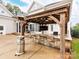 Outdoor kitchen features a built in bar with stone accents, counter seating, fan, and mounted television at 123 Yellow Jacket Cir, Mooresville, NC 28117