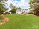 Sprawling backyard with manicured lawn, mature trees, fencing, pool, and home exterior at 123 Yellow Jacket Cir, Mooresville, NC 28117