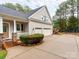 Home exterior features an attached three car garage, stone accents, covered porch, and mature landscaping at 123 Yellow Jacket Cir, Mooresville, NC 28117