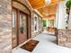 Inviting front porch with stone accents, a wood ceiling, and a stylish wooden front door at 123 Yellow Jacket Cir, Mooresville, NC 28117