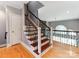 Elegant staircase with wood treads, decorative iron railings, and hardwood floors at 123 Yellow Jacket Cir, Mooresville, NC 28117