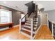 Staircase featuring wood treads, decorative iron railings, and a blend of modern and classic design at 123 Yellow Jacket Cir, Mooresville, NC 28117