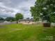 Expansive backyard with a wooden fence, mature tree, and a concrete patio area, ideal for outdoor enjoyment at 133 Pheasant Run Rd, Troutman, NC 28166