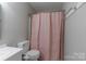 This bathroom features a toilet and shower with pink curtain at 133 Pheasant Run Rd, Troutman, NC 28166