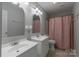 This bathroom features white double sinks and a shower with pink curtain at 133 Pheasant Run Rd, Troutman, NC 28166
