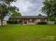 Charming brick home with a well-maintained front yard and mature trees adding to its curb appeal at 133 Pheasant Run Rd, Troutman, NC 28166