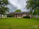Charming home with lush green lawn, mature trees, and well-manicured landscaping at 133 Pheasant Run Rd, Troutman, NC 28166