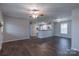 Open living area with hardwood floors, a ceiling fan, and a breakfast bar connecting to the kitchen at 133 Pheasant Run Rd, Troutman, NC 28166