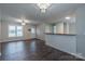 Open living area with hardwood floors, a ceiling fan, and breakfast bar connecting living room, kitchen, and laundry at 133 Pheasant Run Rd, Troutman, NC 28166