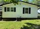 Side of house with white siding, black shutters, and well-maintained lawn at 1401 Woodman Hall St, Shelby, NC 28152