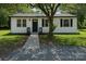 Charming single-story home with white siding, black accents, and a well-maintained front yard and walkway at 1401 Woodman Hall St, Shelby, NC 28152