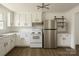 Bright kitchen features white cabinets, new stainless steel appliances, stylish lighting, and wood-look flooring at 1401 Woodman Hall St, Shelby, NC 28152